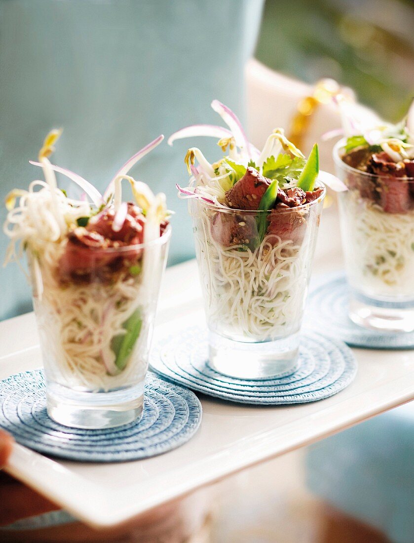 Noodle salad with ostrich meat in glasses