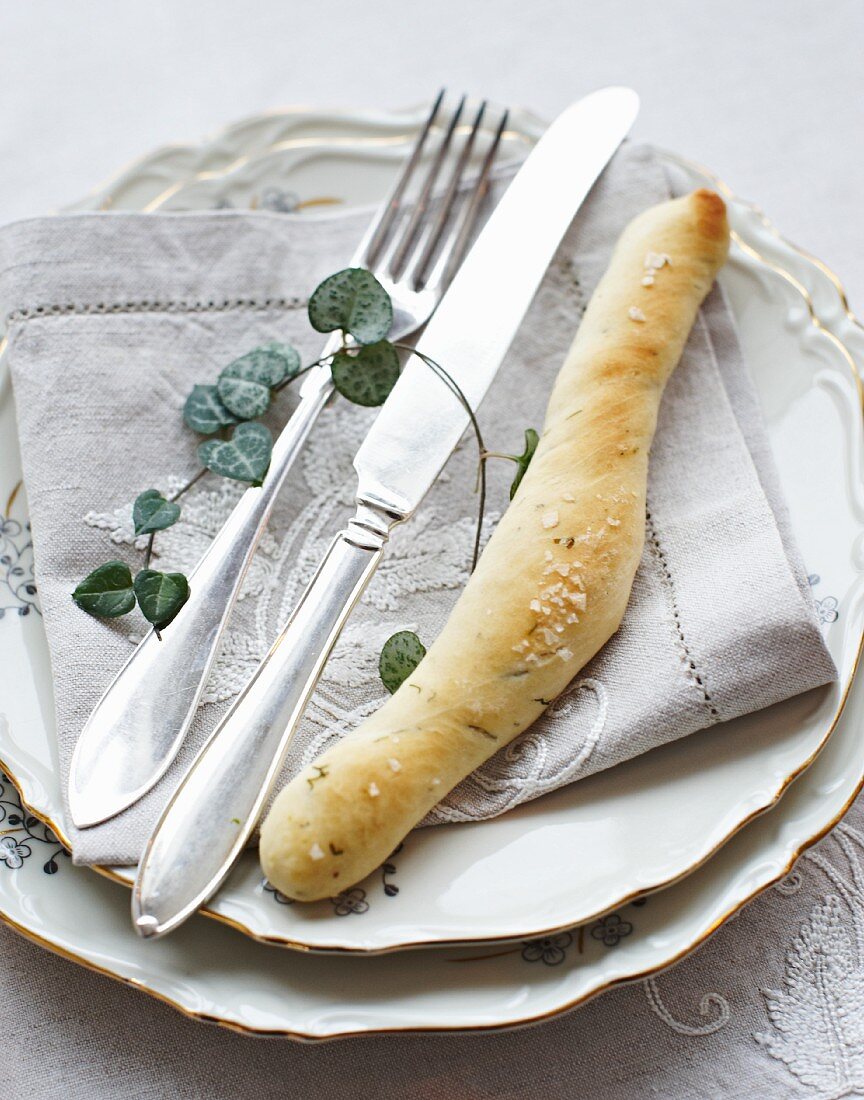 An Easter place setting with dill bread, napkin and cutlery