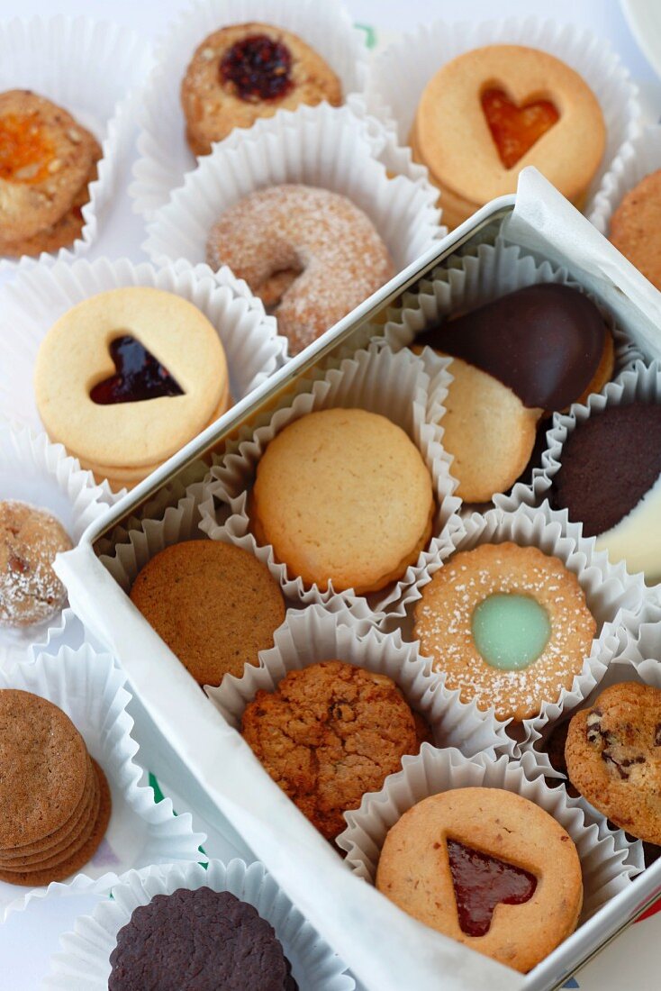 A white gift box with various cookies and Linz sandwich biscuits