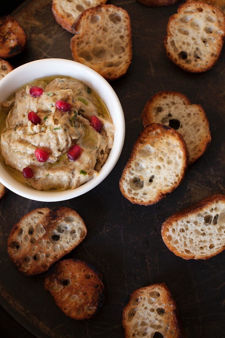 An aubergine dip with pomegranate seeds and grilled bread