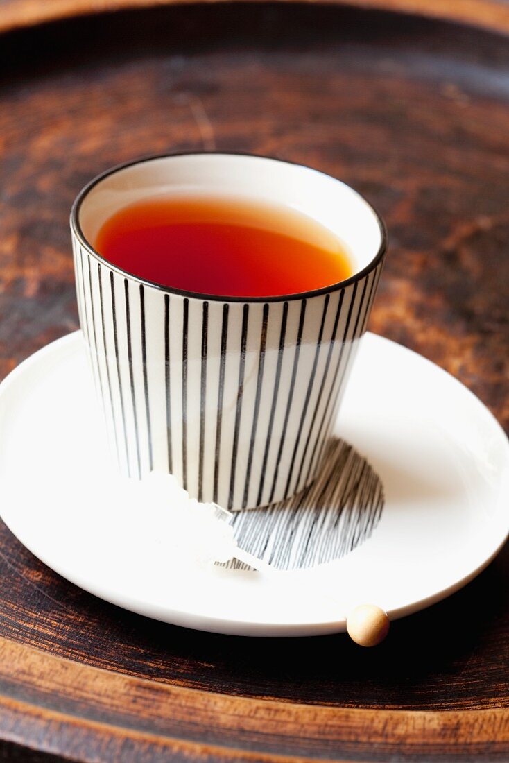 A cup of rooibos tea with a rock sugar stick