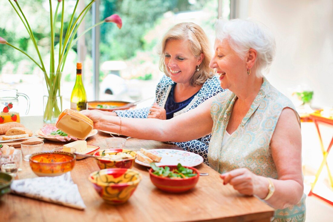Zwei Frauen beim gemeinsamen Essen am gedeckten Esstisch