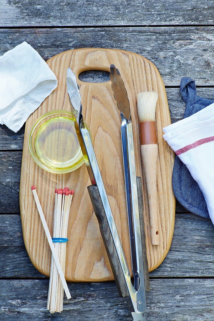Various grilling utensils on a chopping board