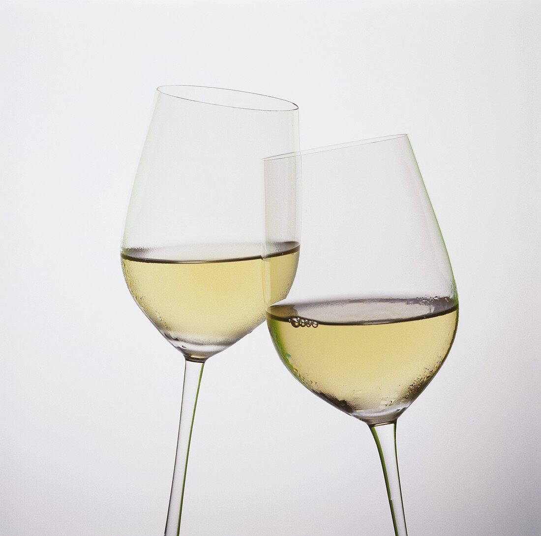 Two tilted white wine glasses