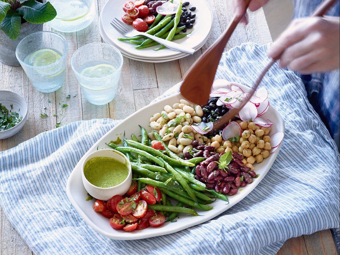 A five bean salad with radishes and tomatoes being served