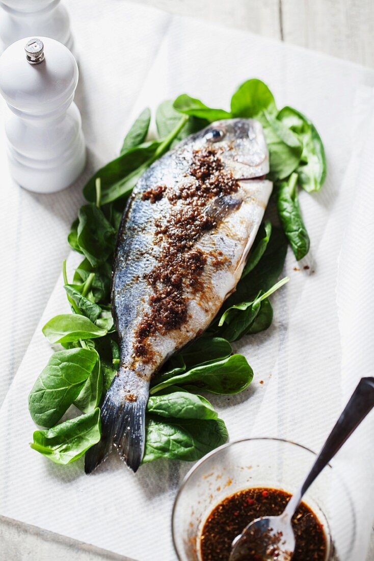 Seabream with a spicy marinade on a bed of spinach