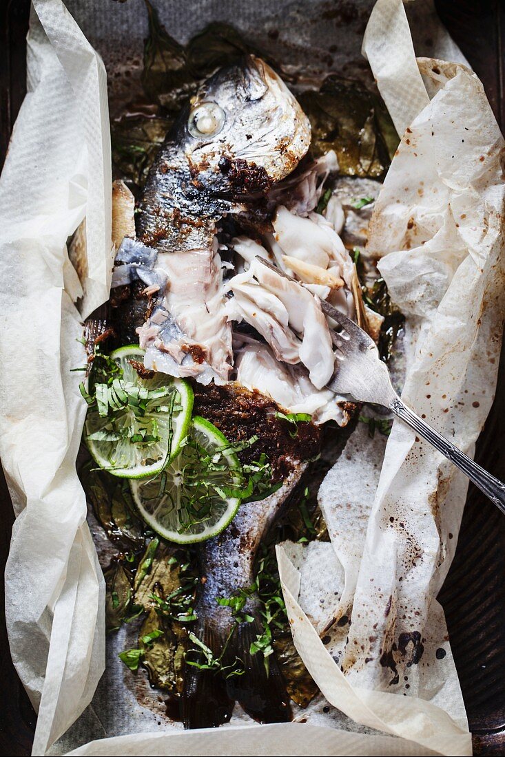 Marinated seabream with limes in parchment paper (bites taken out)