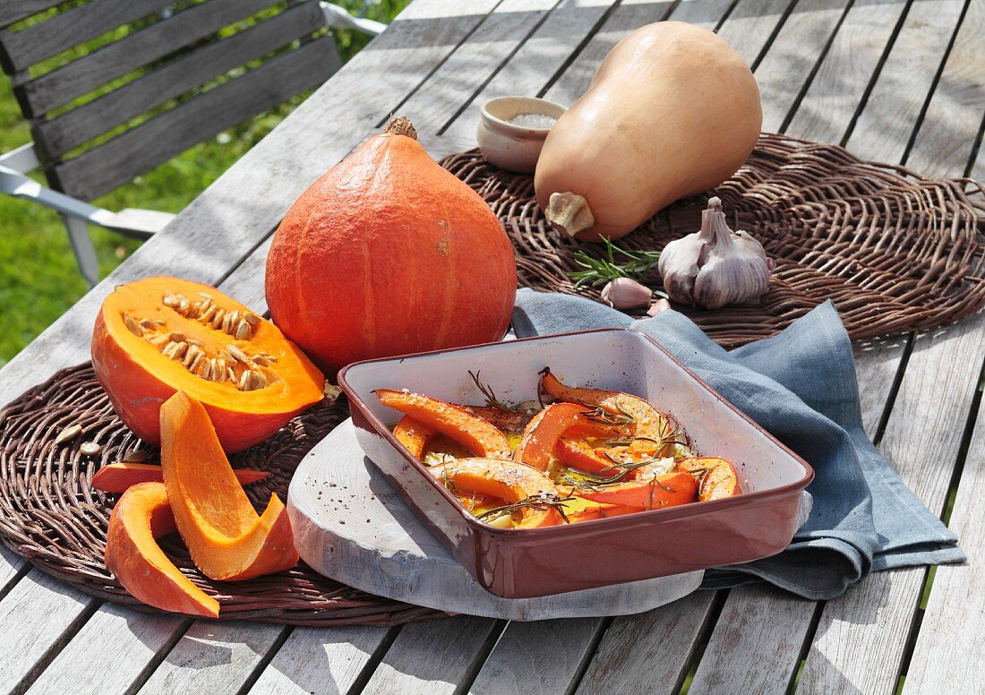 Pumpkin, fresh and roasted, on a garden table