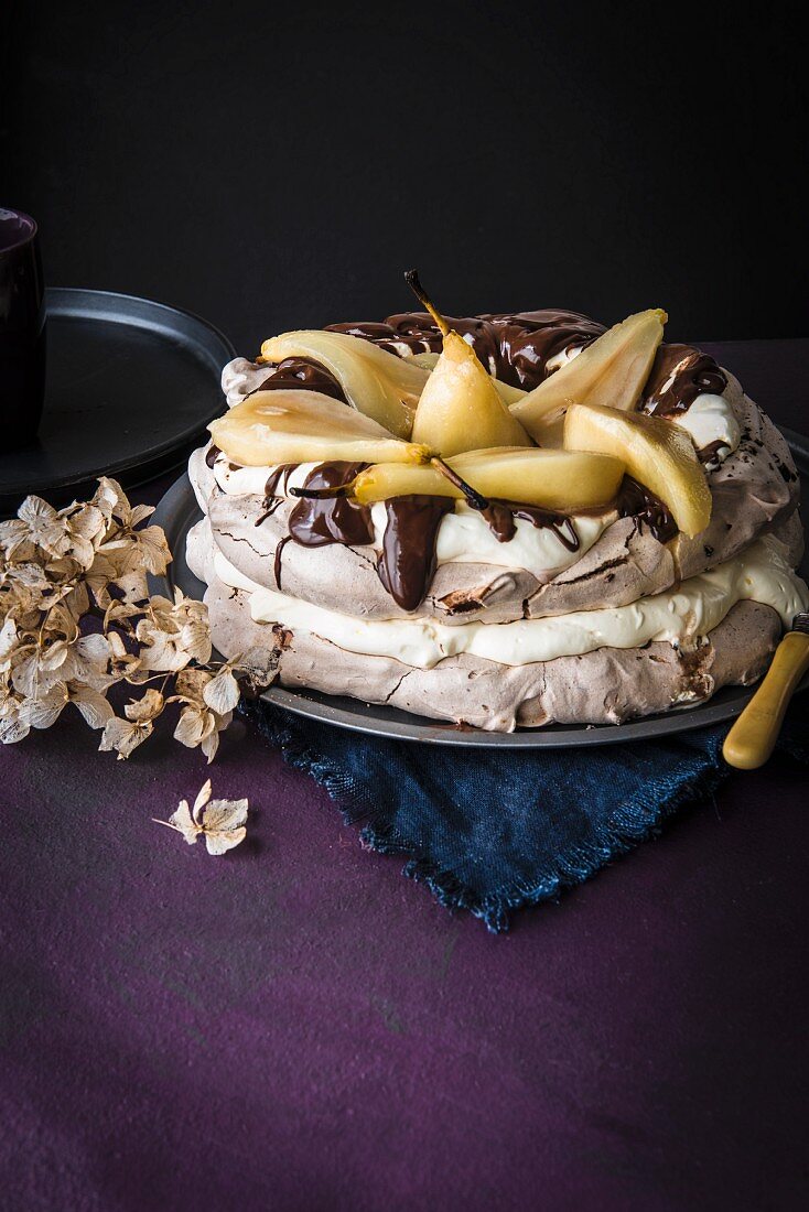 Chocolate pavlova with poached pears, dark chocolate and cream