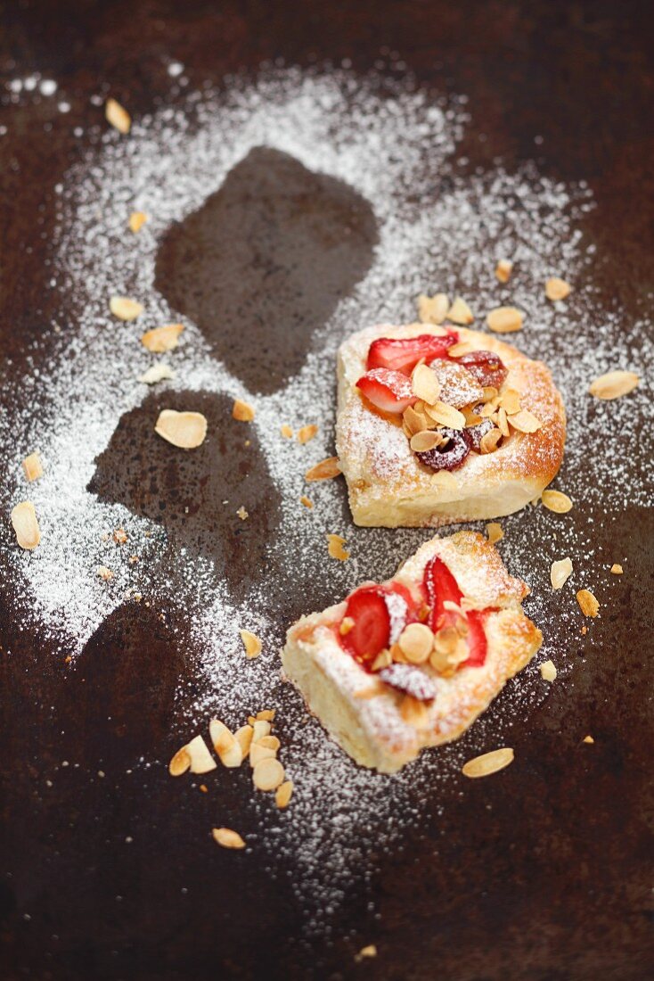 Sweet yeast dough cakes with berries and flaked almonds