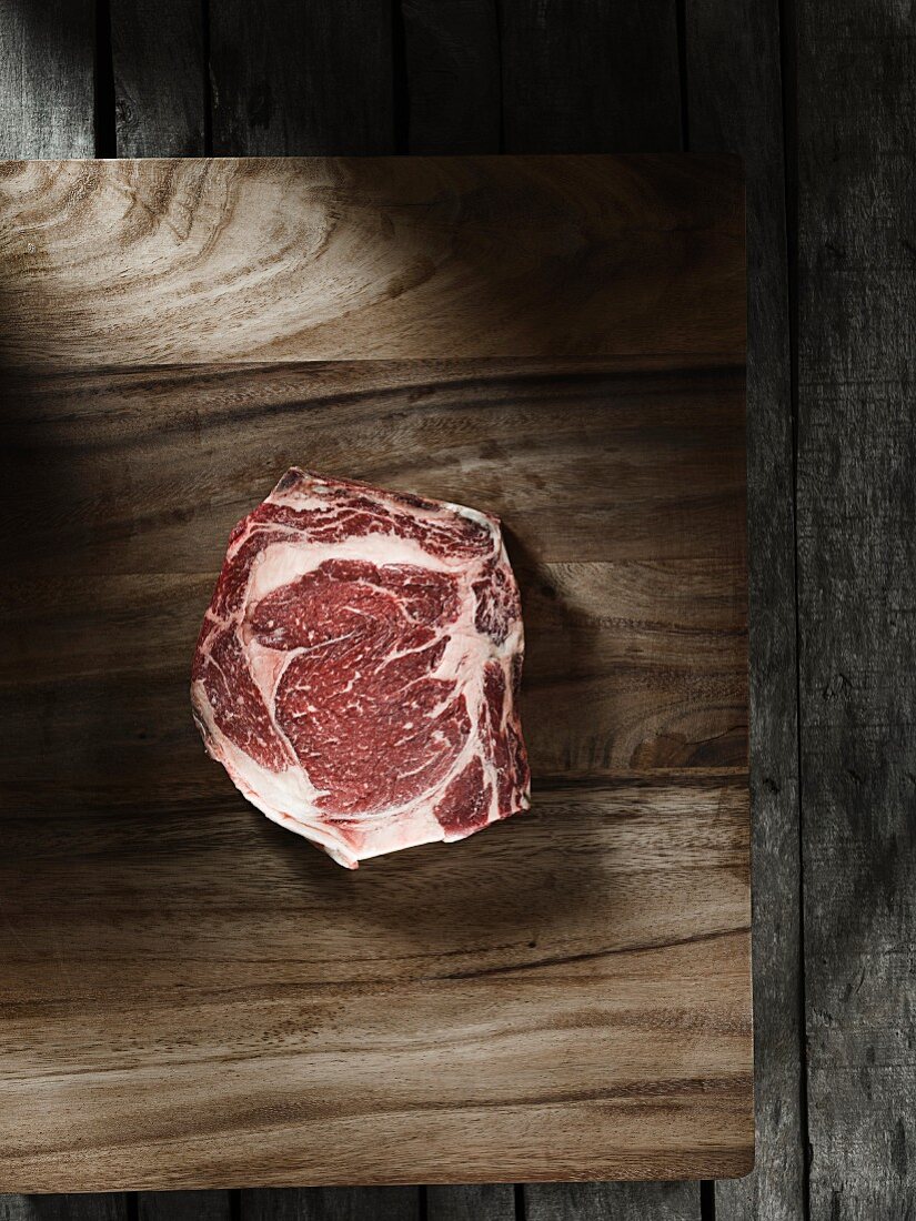 A raw, marbled rib-eye steak
