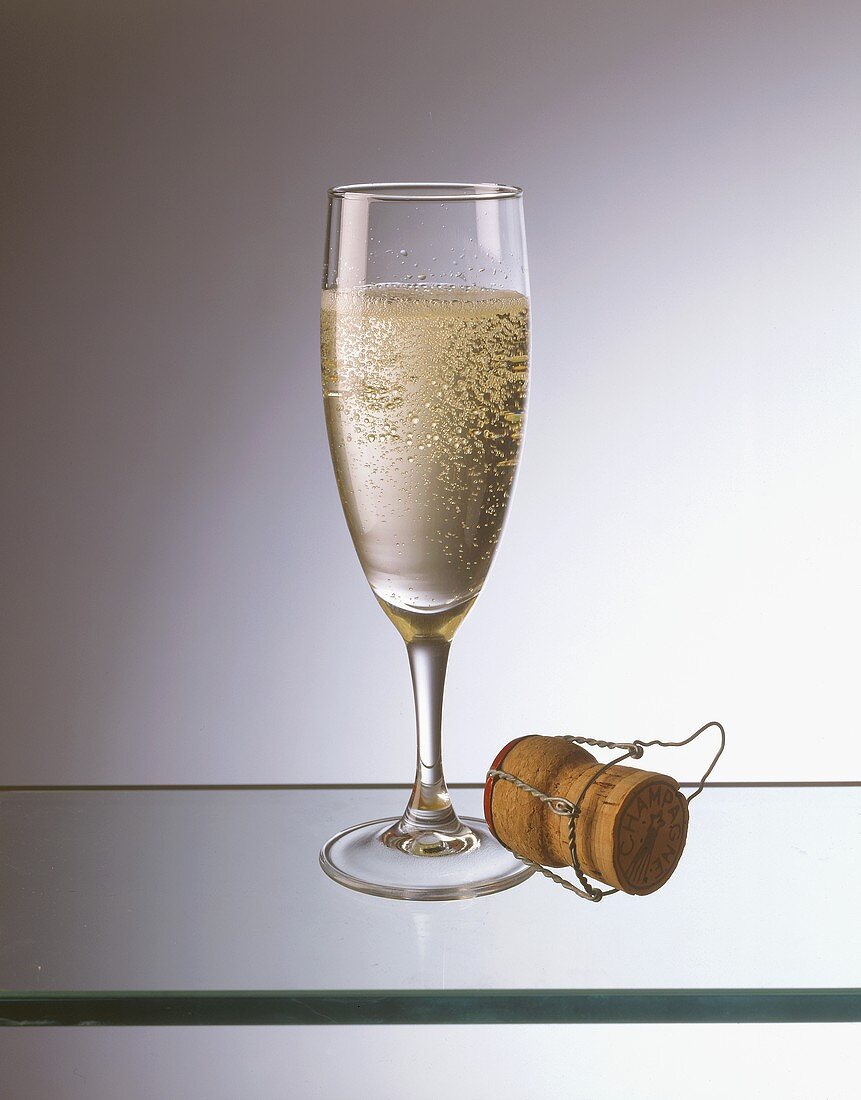 Champagne glass, with champagne cork beside it