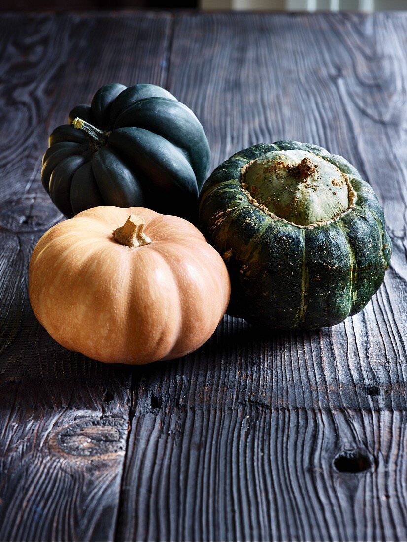 Three squash on a grey wooden table