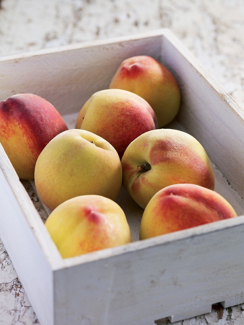 Peaches in a white wooden crate