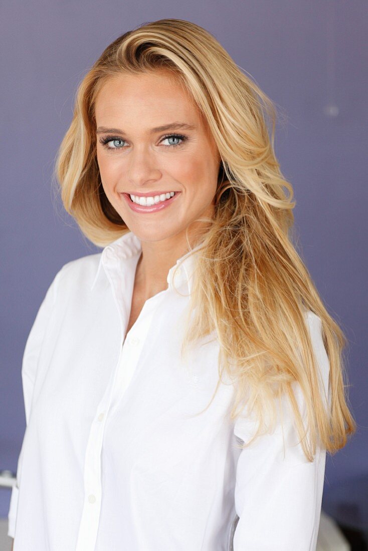 A young blonde woman wearing a white blouse