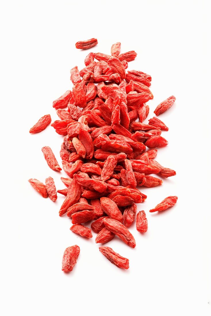 Dried goji berries on a white surface
