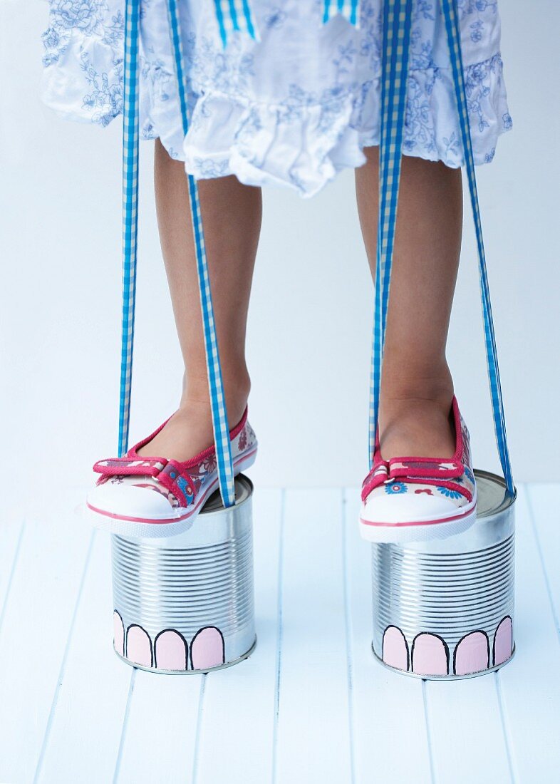 Stilts painted to look like elephant feet hand-made from tin cans and ribbon