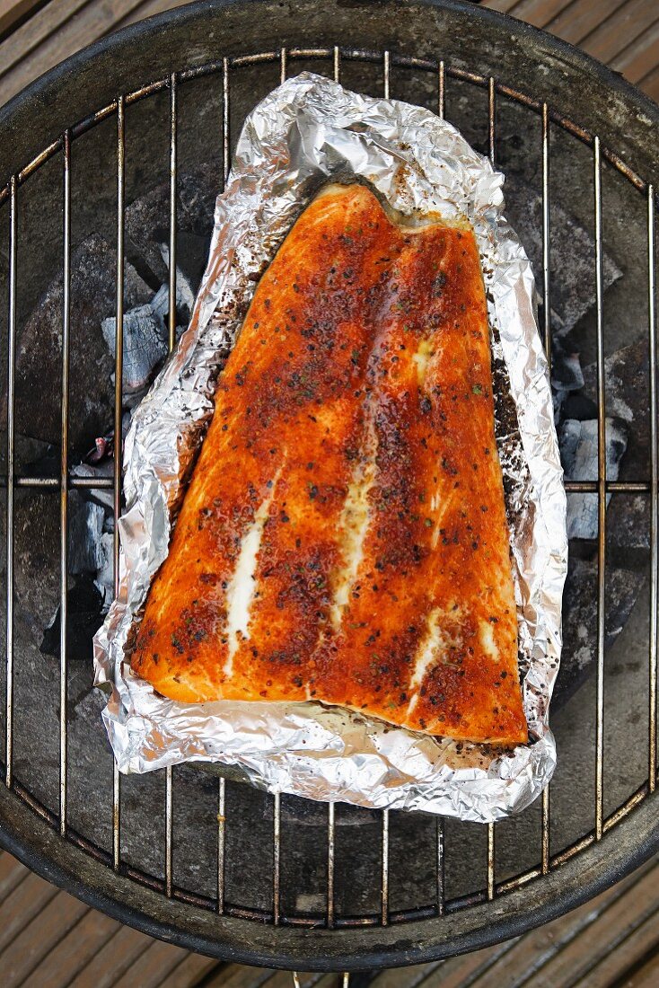 Spiced salmon in aluminium foil on a barbecue