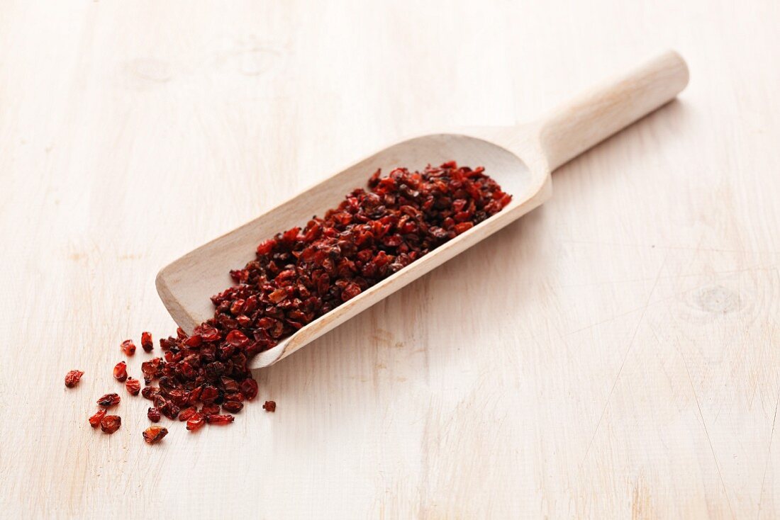 Dried barberries on a wooden scoop
