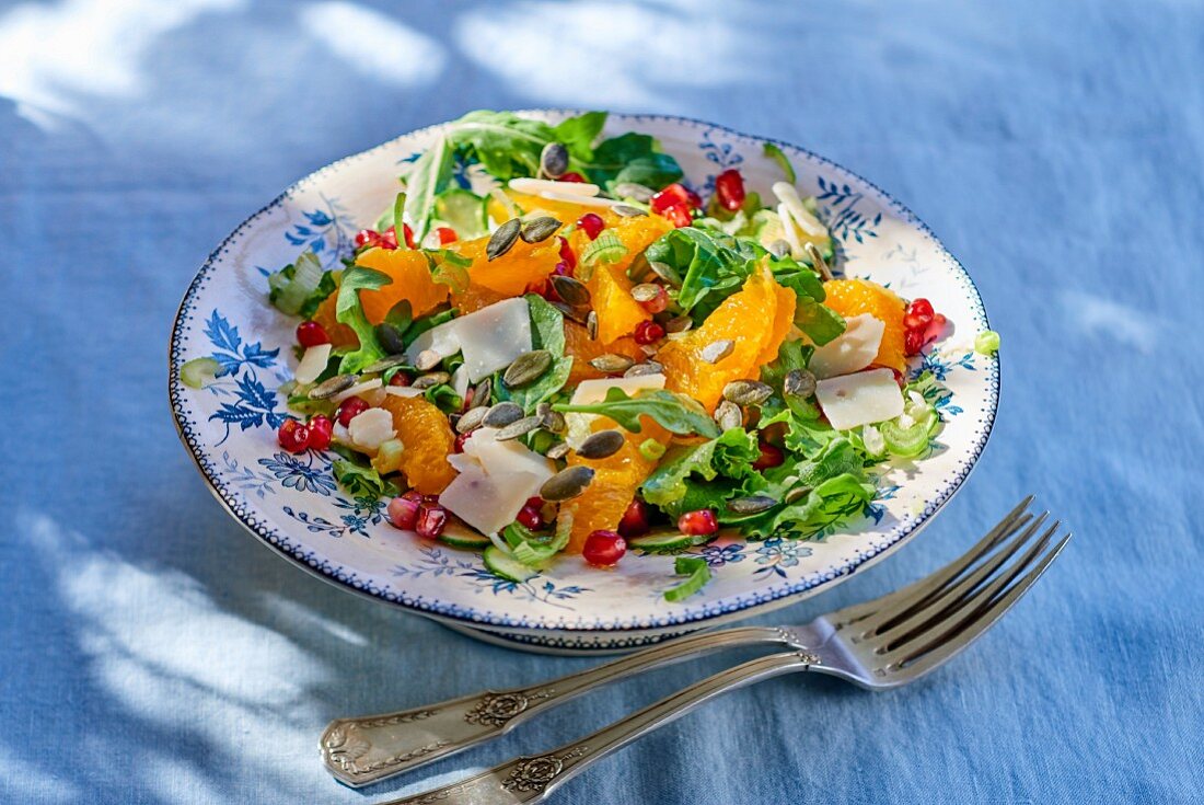 Rocket salad with oranges, pomegranate seeds, Parmesan cheese and pumpkin seeds