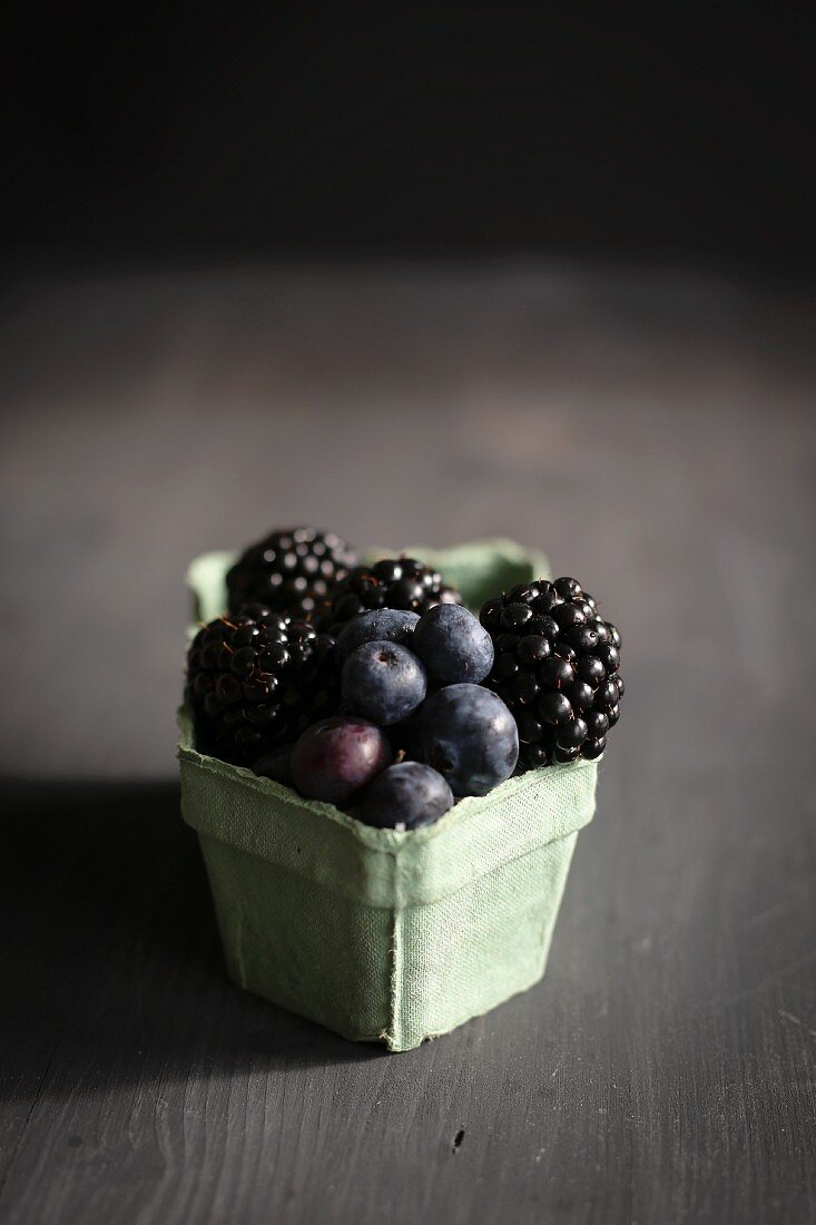 Heidelbeeren und Brombeeren in altmodischem Pappschälchen