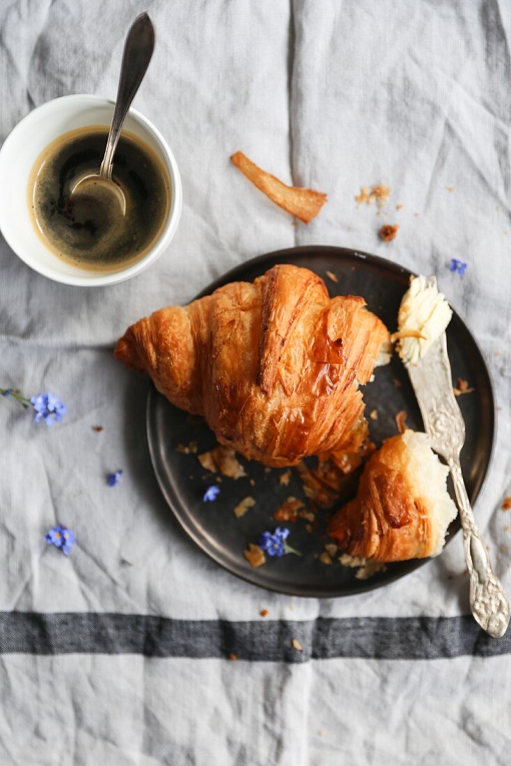 Croissant, Buttermesser und Kaffee