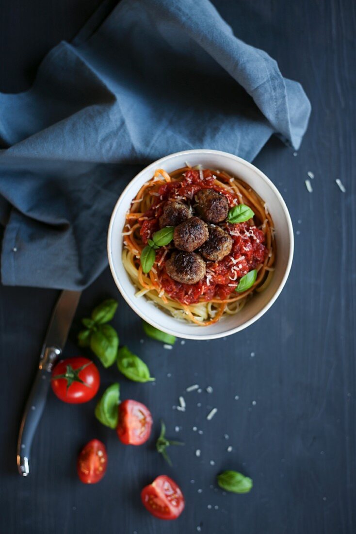 Spaghetti with meatballs, tomato sauce and basil (seen from above)
