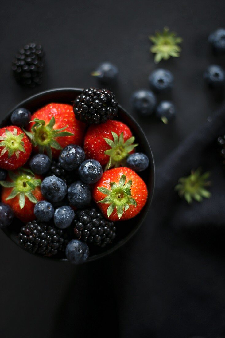 Various berries in a black bowl