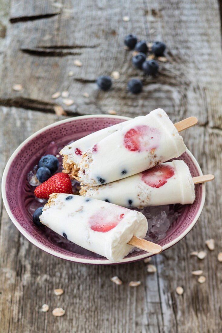 Frozen yoghurt on sticks with cereals and berries