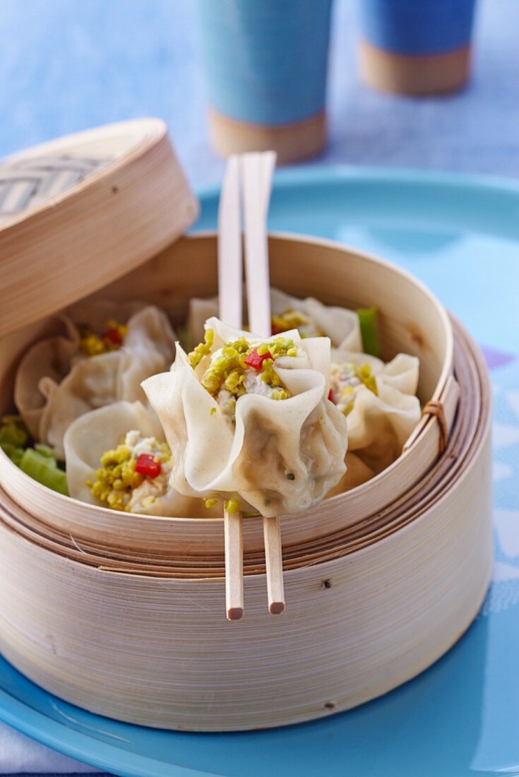 Wontons filled with chicken and pistachio nuts in a steamer basket