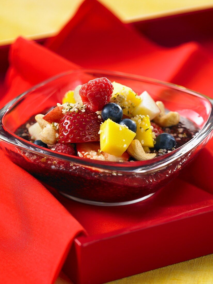 Obstsalat mit Erdbeeren, Himbeeren, Blaubeeren, Mango, Cashewkernen und Acaisaft