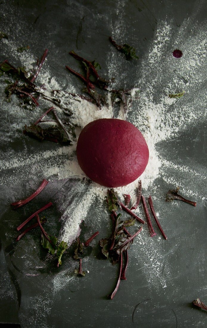 Rote-Bete-Pastateig zu Kugel geformt auf bemehltem Untergrund