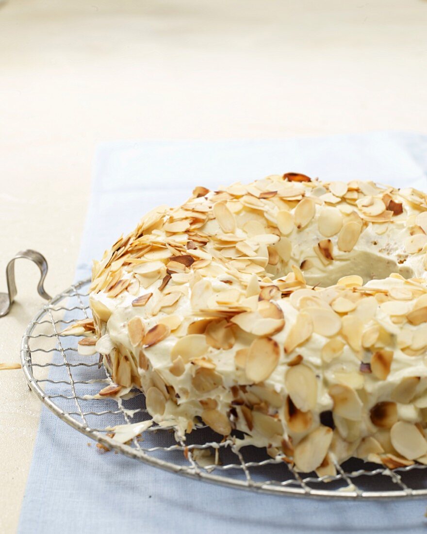 Frankfurt wreath cake with flaked almonds on a wire rack