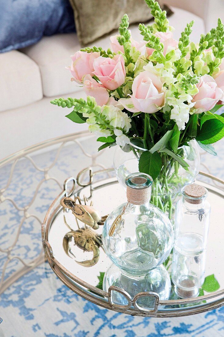 Romantic, pink bouquet of roses on a silver tray with a glass carafe