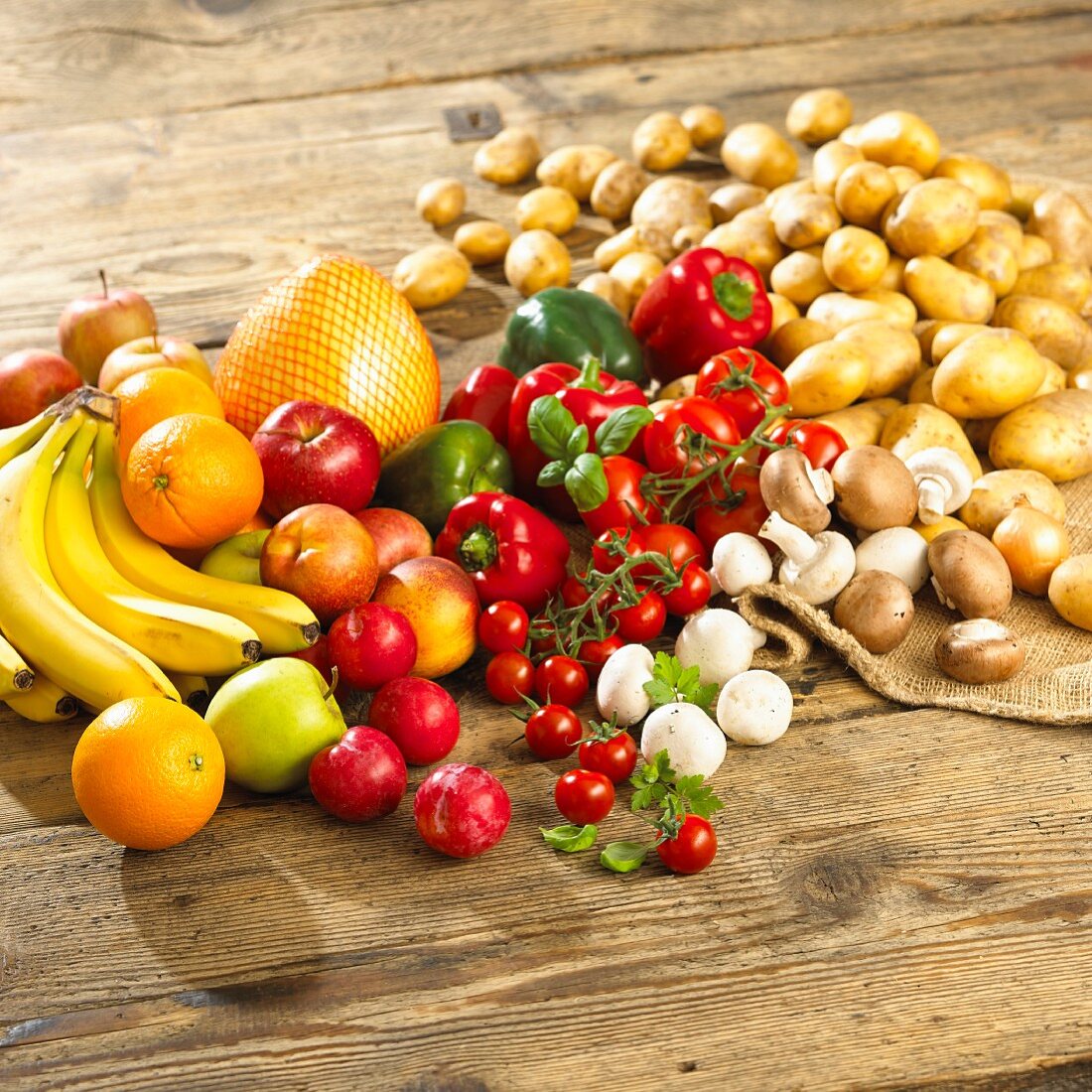 Gemüsestillleben mit Champignons und Obst auf Holztisch