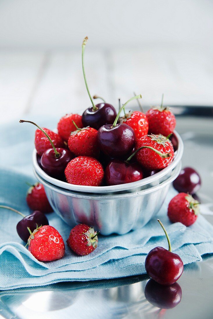 Strawberries and cherries in a metal bowl