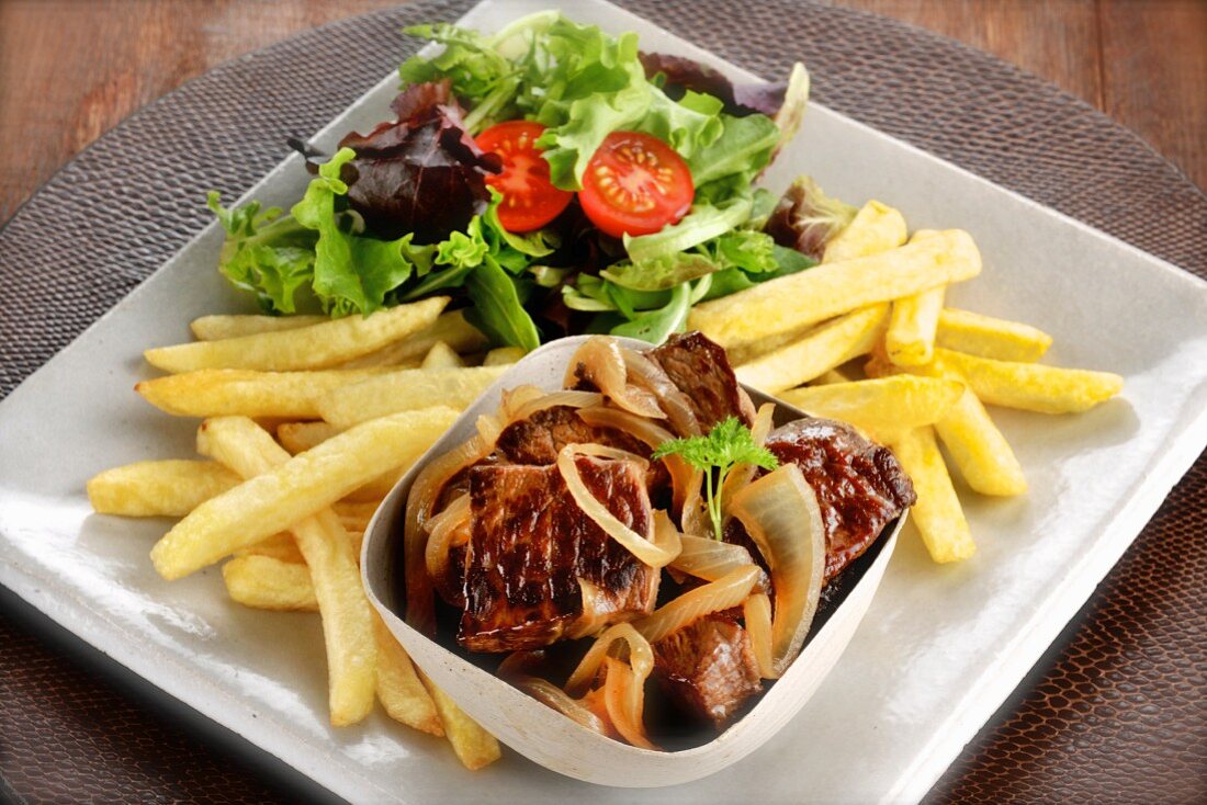 Steak mit Zwiebeln, Salat und Pommes Frites