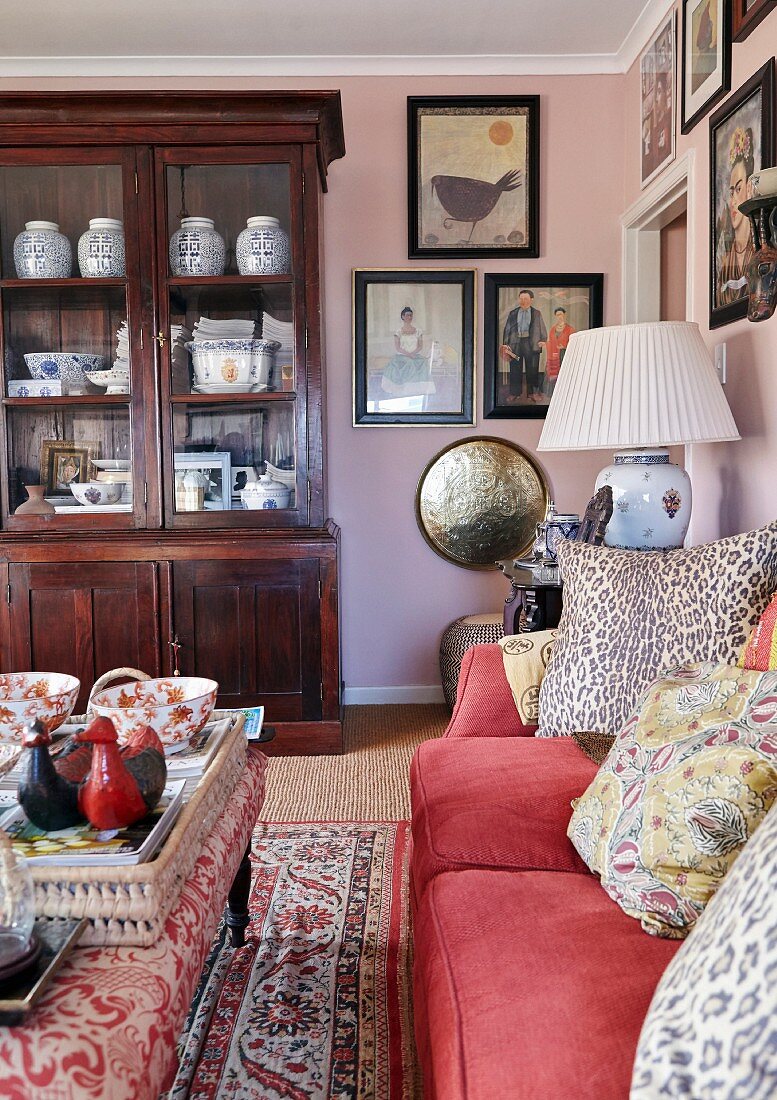 Gallery of pictures and antique display cabinet in eclectic living room