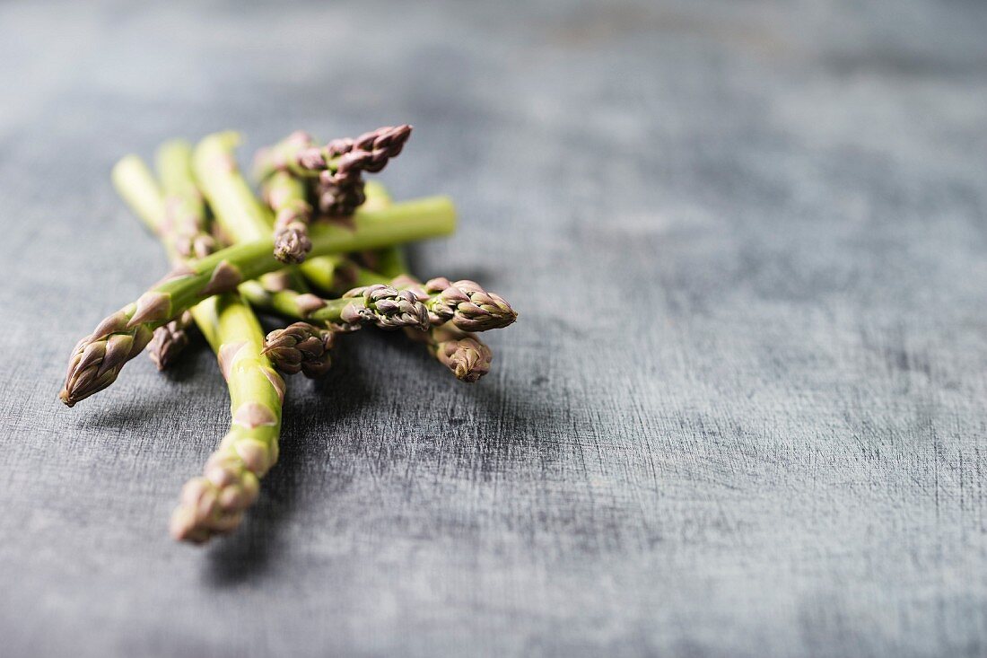 Green asparagus spears on a grey surface