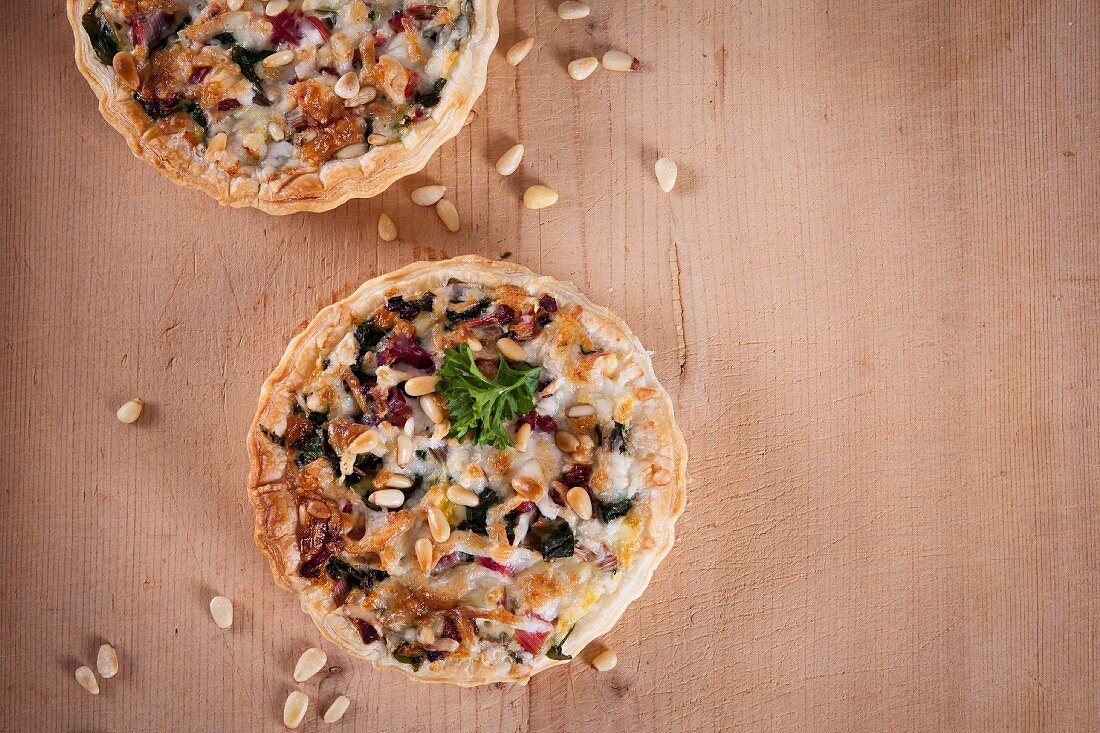 Puff pastry quiche with chard, bacon, goat's cheese and pine nuts
