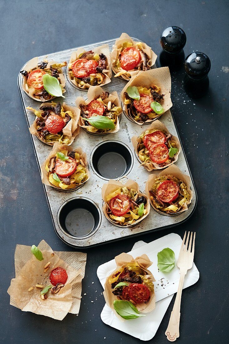 Pasta nests with tomatoes in a muffin tin