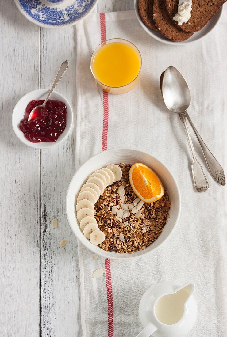 Granola-Müsli mit Banane und Orange zum Frühstück (Aufsicht)