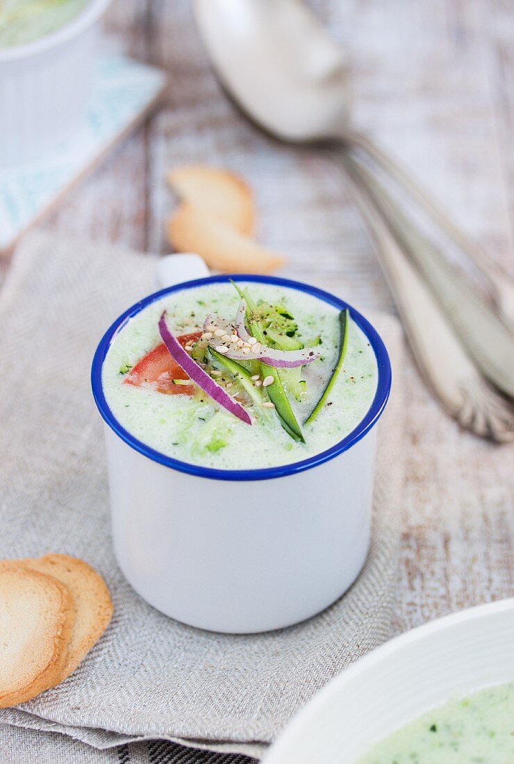 Cold courgette and cucumber soup in an enamel mug