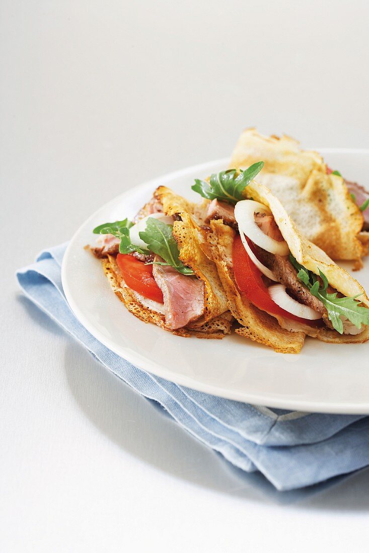 Pfannkuchen mit Rindersteak, Tomate, Zwiebel und Rucola