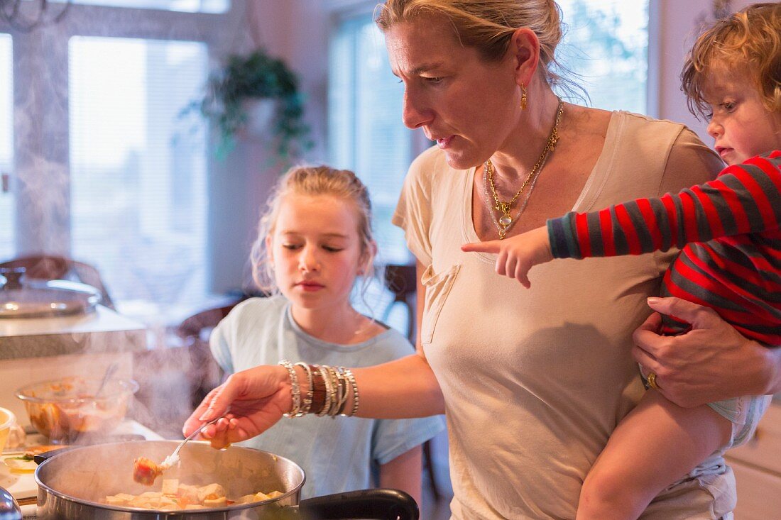 Frau mit Kindern beim Kochen