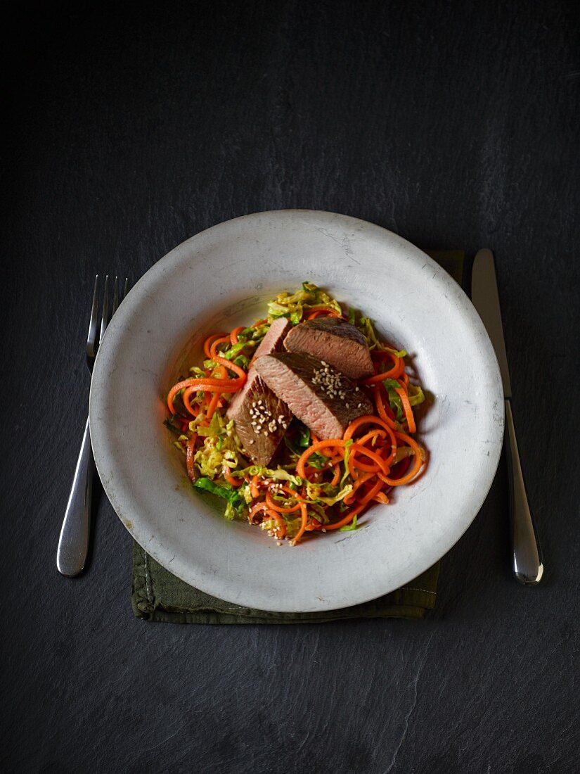 Lamb fillet on a bed of Brussels sprouts and carrot pasta