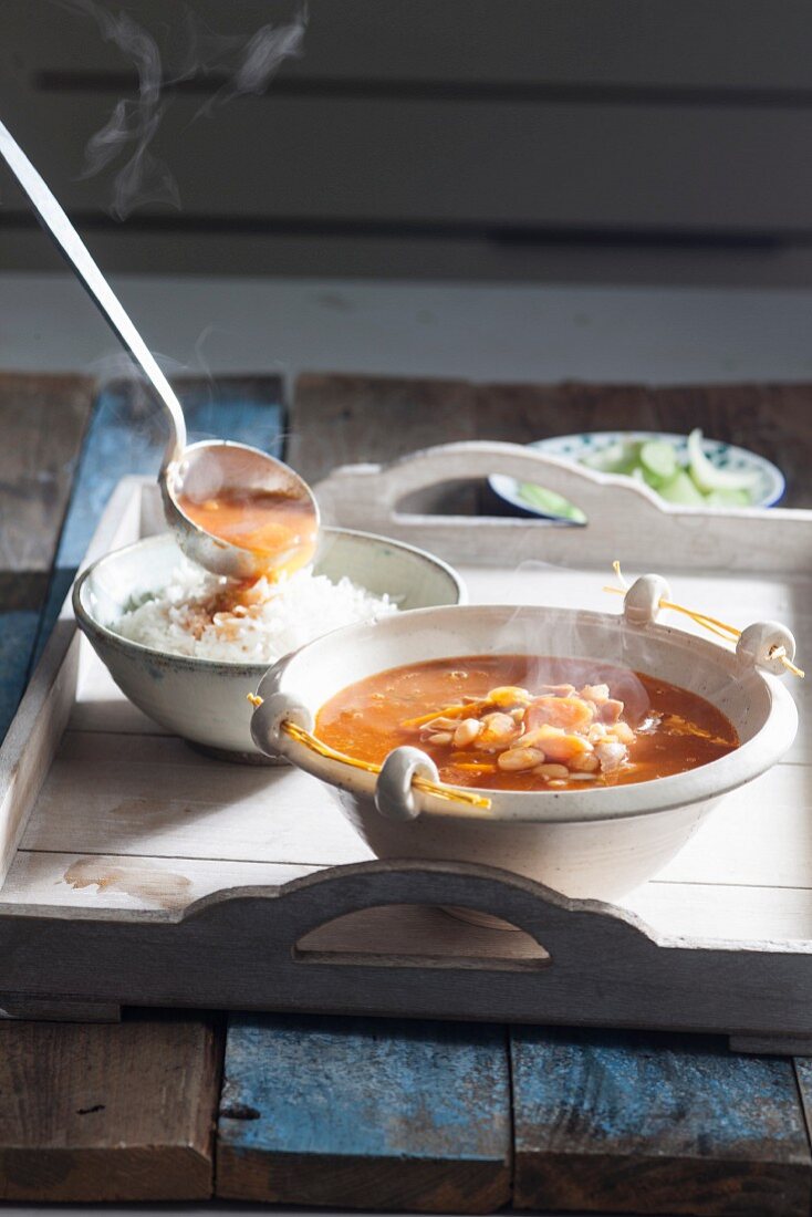 Steaming bean soup with chicken on a tray