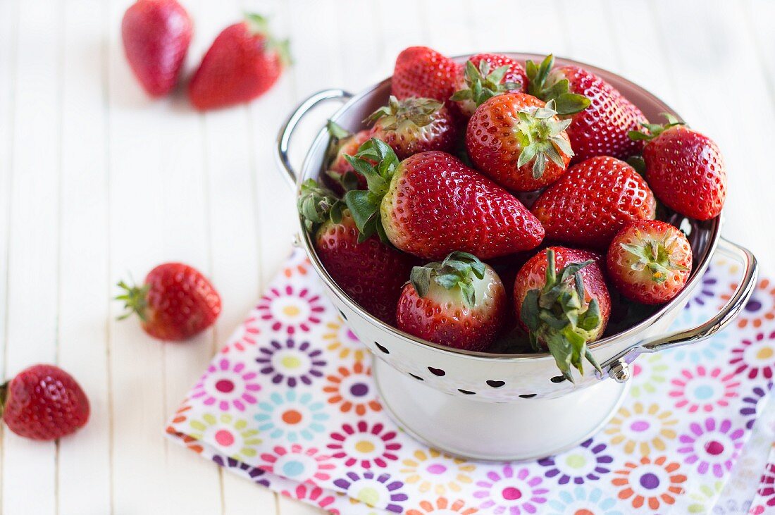 Fresh strawberries in an enamel colander