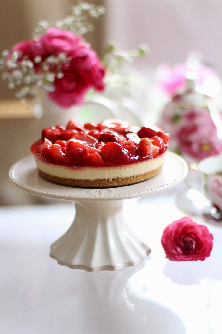 A mini strawberry tart on a cake stand