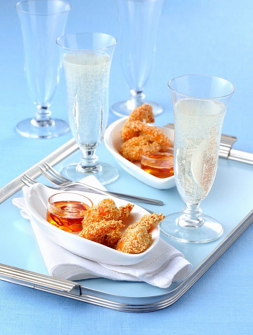 Fried sesame seed prawns with a chilli dip and glasses of champagne